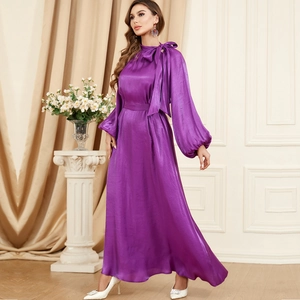 Detail of purple satin long sleeve dress with bow neckline and tied waist design