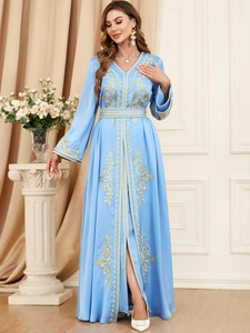 Detail of light blue kaftan dress with golden embroidery and elegant side slit
