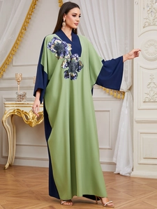 Close-up of contrast patchwork kaftan with sequined floral embroidery and V-neckline