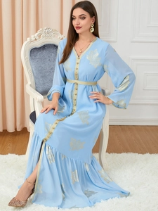 Detail von goldenem Blattmuster und Borte an einem hellblauen Kaftan-Kleid im Ethno-Stil