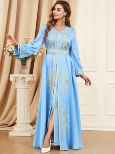 Detailed close-up of golden embroidery on light blue satin long-sleeved kaftan dress