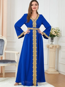 Close-up of golden lace embroidery on deep blue kaftan robe dress with V-neck detail
