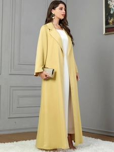 Detail view of yellow long lapel cardigan with premium fabric and striped metallic clutch