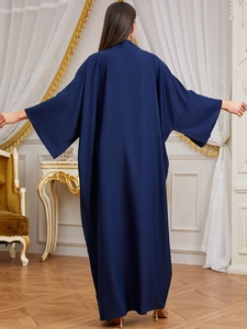 Rear view of navy blue loose maxi dress with batwing sleeves in a luxury vintage setting