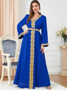 Detail of gold embroidery on dark blue kaftan dress with elegant V-neck and lace trim