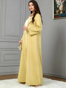 Detail of light yellow long cardigan abaya featuring elegant draped fabric and long sleeves