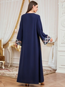 Détail de la manche d'une abaya bleu marine avec broderie florale géométrique et paillettes