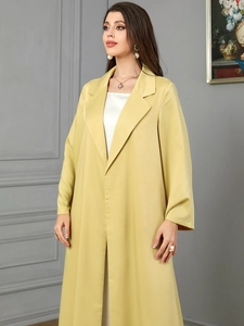 Detail of elegant long-sleeved yellow lapel coat with premium smooth draped fabric