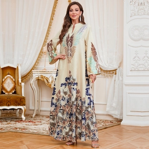Elegant long-sleeved floral kaftan dress in beige with blue botanical prints and V-neckline