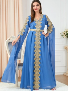 Detail of dark blue kaftan with gold lace floral embroidery and V-neckline design