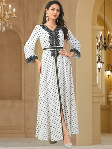 Detailed view of the black lace trim on the V-neckline and sleeve cuffs of the polka dot dress