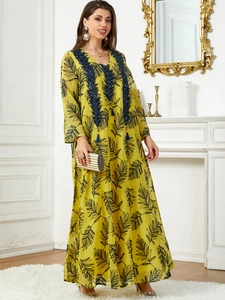 Robe caftan jaune élégante avec imprimé feuilles et détails de glands bleus