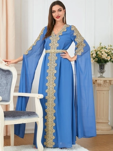 Detail of blue kaftan dress showing golden lace embroidery and metallic buckle belt