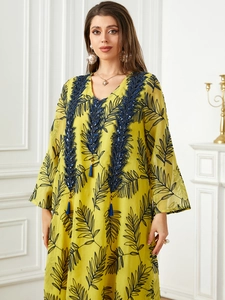 Robe longue élégante en mousseline jaune avec broderie bleue et détails de glands