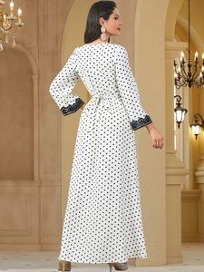Detailed back view of white polka dot maxi dress with lace cuffs and waist tie bow