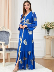 Detail von goldenen Blattdrucken und verzierten V-Ausschnitten auf blauem Kaftankleid