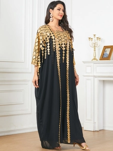 Intricate gold geometric embroidery and sequins on a black long sleeve kaftan dress