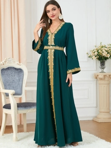 Detail of elegant dark green Abaya dress featuring intricate gold embroidery on the waist