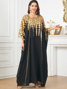 Detailed view of intricate gold sequin embroidery on black caftan dress with ethnic motifs