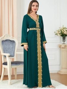Detail of elegant dark green robe with intricate gold embroidery and long sleeves