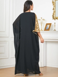 Detail of gold geometric embroidery and sequins on sleeve of black chiffon dress