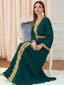 Detail of emerald green kaftan with intricate gold embroidery on cuffs and waist