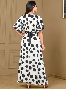 Polka dot maxi dress with ruffle sleeves and black ribbon belt shown from the back view