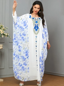 Detail showing high-quality floral print and blue embroidery on long white kaftan robe