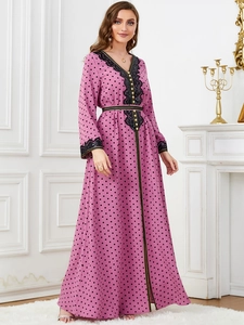 Detail of V-neckline with black lace trim and buttons on pink polka dot dress