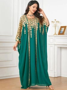 Close-up of golden geometric diamond embroidery on long sleeve green kaftan dress