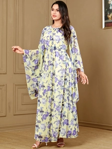 Détail d'une robe longue fleurie en mousseline avec manches évasées et motif bohème élégant