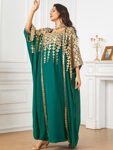 Macro detail of intricate gold embroidery and sequins on a dark green chiffon kaftan dress
