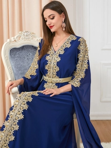 Detailed embroidery with gold lace and beads on a navy blue long sleeve kaftan dress