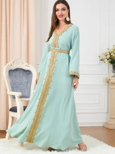 Detail view of mint green Kaftan dress with intricate gold embroidery and V-neckline