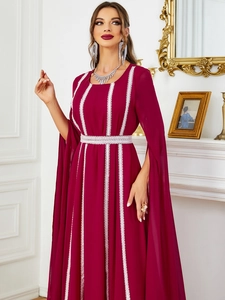 Dettaglio dell'abito lungo bordeaux con pizzo bianco e maniche a mantella aperte