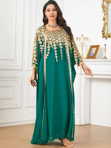 Detail of dark green kaftan with intricate gold geometric embroidery and tassels