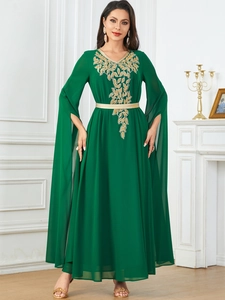 Detail of dark green chiffon maxi dress with gold leaf embroidery and cape-style slit sleeves