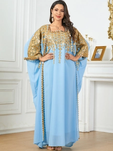 Detailed view of luxury light blue kaftan with intricate gold embroidery and sequins