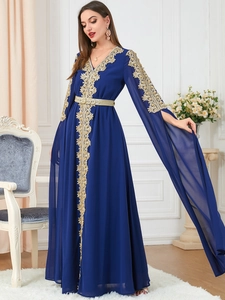 Detail of navy maxi dress featuring gold embroidery and elegant split long sleeves
