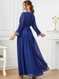 Detail of royal blue chiffon dress sleeve featuring intricate white floral embroidery patterns