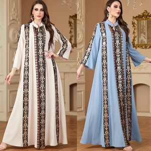Detail view of ethnic embroidery on V-neck long-sleeve abaya dress in white and blue
