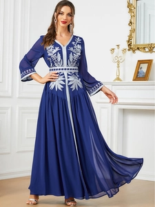 Macro view of exquisite silver leaf embroidery on navy blue kaftan evening gown