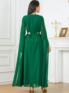 Detail of emerald green maxi dress with split cape sleeves and a gold waist tie
