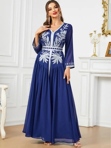 Detail of silver floral embroidery on a deep blue V-neck maxi dress with high waist design