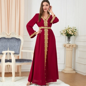 Elegant wine red kaftan dress with golden embroidery and long sleeves in a vintage setting