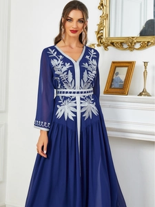 Detail of silver floral embroidery and braided trim on a navy kaftan maxi dress