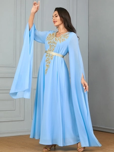 Detail of light blue dress with golden leaf embroidery and split long sleeves