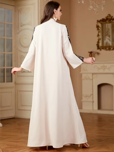 Detail of elegant cream abaya featuring intricate floral embroidery on the long sleeves