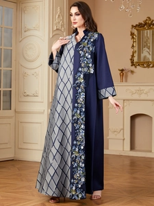 Détail d'une abaya asymétrique élégante avec broderie florale et coutures contrastées
