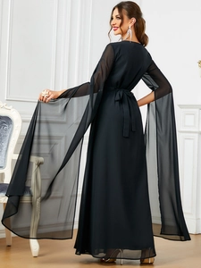 Dettaglio abito da sera nero con maniche lunghe a fessura in chiffon ed effetto mantella